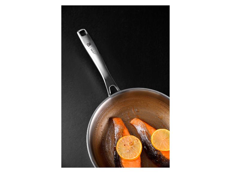 Koekenpan met zalm en citroen op een zwarte achtergrond