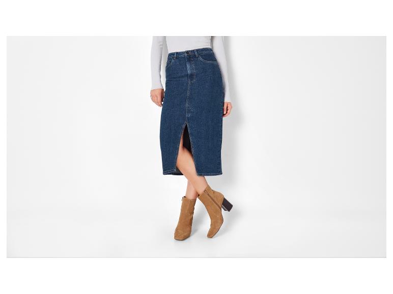 Een vrouw draagt ​​een blauwe denim rok en bruine enkellaarsjes.