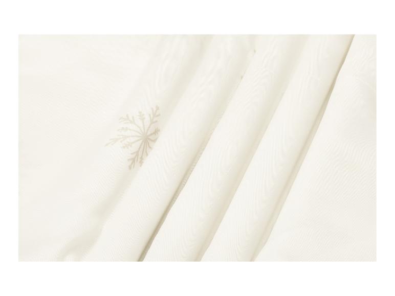 Crèmekleurige stof met een subtiel sneeuwvlokpatroon en zachte plooien.