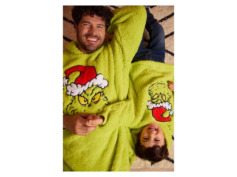 Lachende vader en zoon in bijpassende pluizige Grinch-hoodies