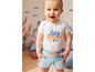 Baby in een wit shirt met octopus en een blauwe denim short.
