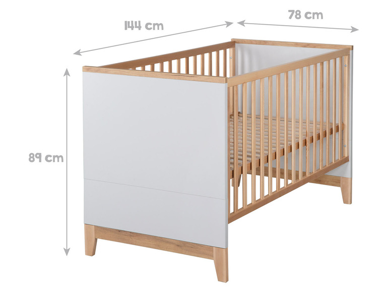 Een wit babybedje met houten latten en poten.