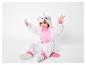 Zittend kind in een witte en roze eenhoorn onesie.