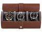 Drie elegante polshorloges in een lichtbruine opbergdoos.