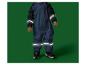 Kind in een marineblauwe waterdichte overall met reflecterende strepen en zwarte sneakers.