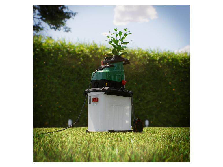 Een Bosch tuinhakmolen op een gazon, klaar voor gebruik.