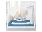 Wit daybed met hemelbed, blauw en wit beddengoed en rolkussens.