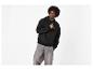 Man in zwarte hoodie met motief en grijze jeans