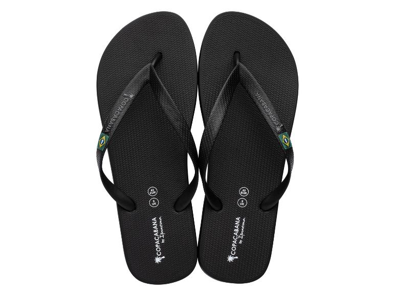 Een paar zwarte teenslippers met een Braziliaanse vlag en de tekst 'COPACABANA'.