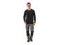 Man in zwart shirt met lange mouwen en grijze werkbroek.