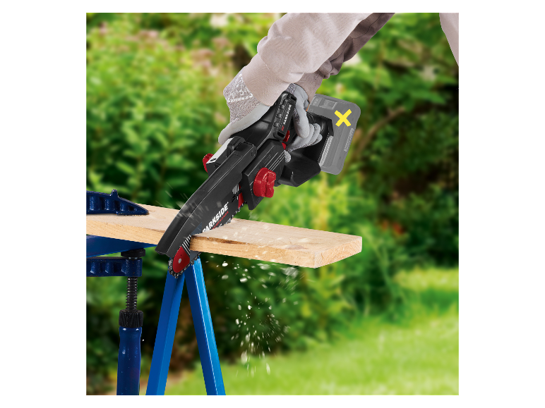 Iemand gebruikt een Parkside accu kettingzaag om een stuk hout te zagen.