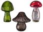 Drie decoratieve glazen paddenstoelen in groen, bruin en rood met zilveren accenten.