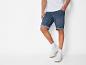 Herenshorts van jeans en witte sneakers.