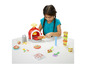 Een meisje maakt pizza's met Play-Doh deeg en een speelgoed oven.
