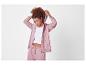 Vrouw in roze hoodie en bijpassende joggingbroek.