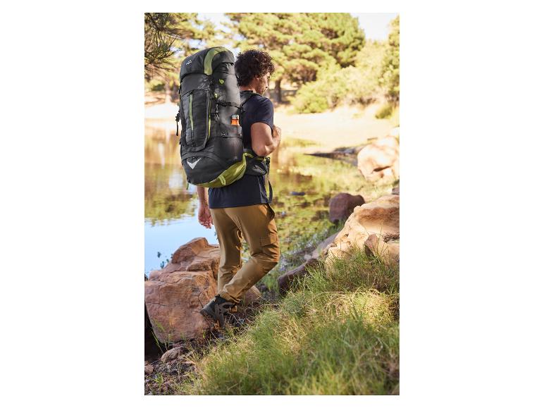 Man met Quechua rugzak en wandelschoenen bij een meer.