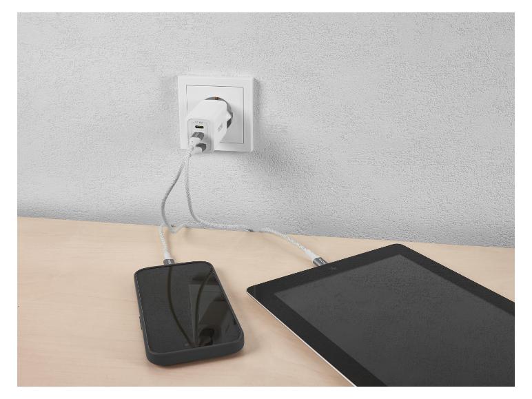 PD 45W netlader laadt telefoon en tablet op een houten tafel op.