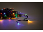 Kleurrijke kerstverlichting op dennentakken, creëert een feestelijke sfeer.