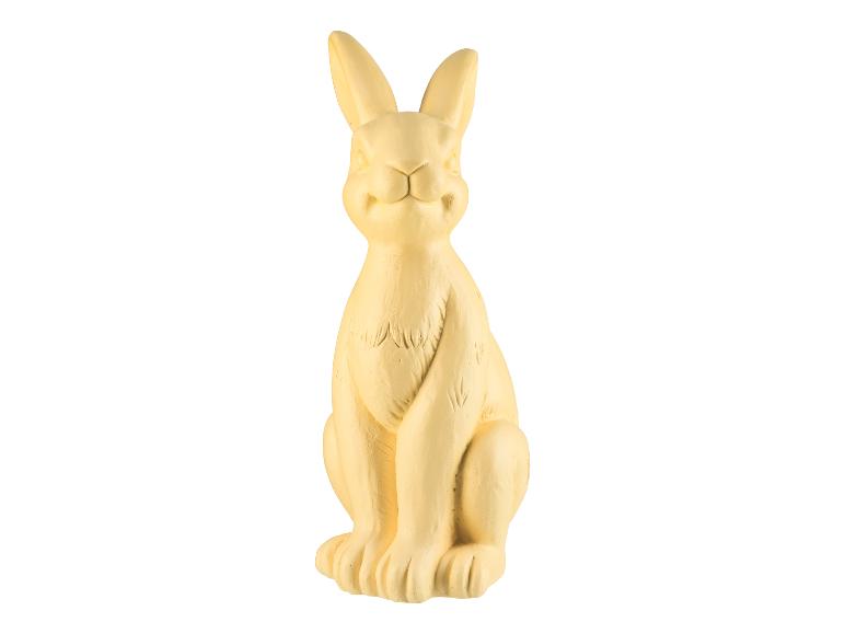 Een gele, zittende konijnenfiguur.