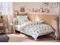 Gezellige kinderkamer met een bed met dinosaurusbeddengoed en speelse decoratie.