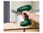 Hand houdt Parkside accuboormachine vast, schroeft een schroef in een kast.