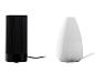 Twee aroma diffusers: een zwarte cilindervormige en een witte druppelvormige.