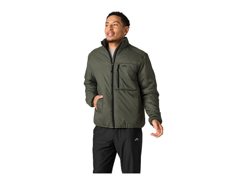 Man in een olijfgroene jas en zwarte broek, met zijn hand in zijn zak.