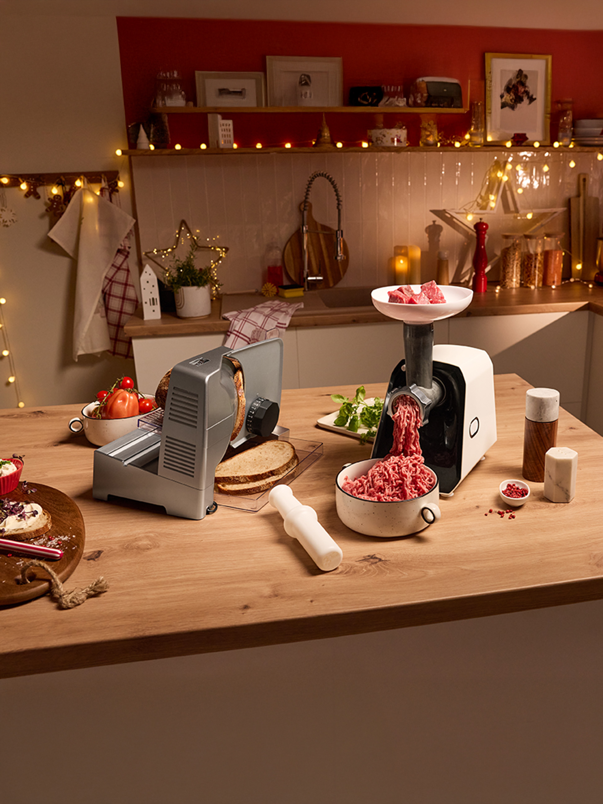Vleesmolen en broodsnijder op een feestelijk versierd aanrecht.