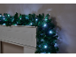 Kerstslinger met witte LED-lampjes gedrapeerd over een witte schouw.