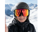 Vrouw met skibril en helm voor besneeuwde bergen.