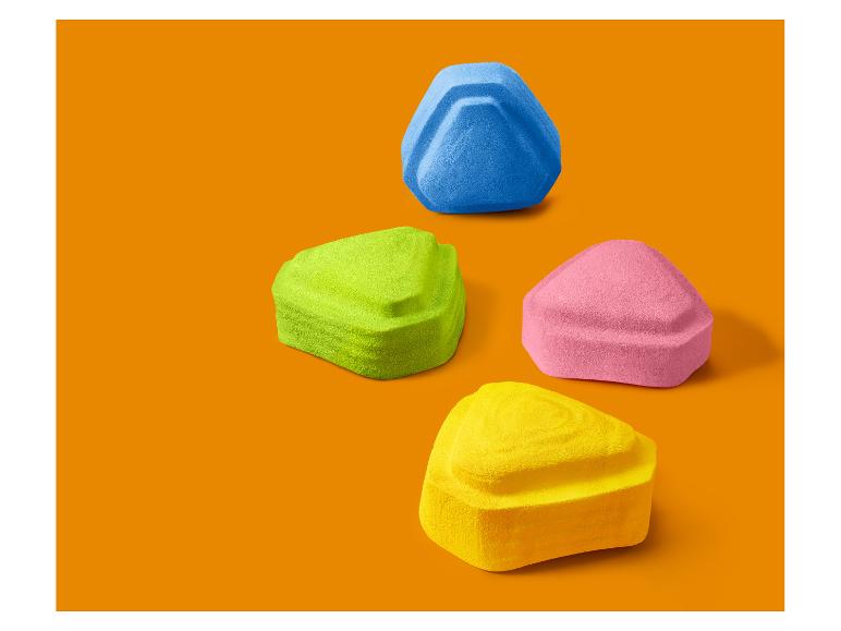 Vier kleurrijke driehoekige make-upsponsjes op een oranje achtergrond.