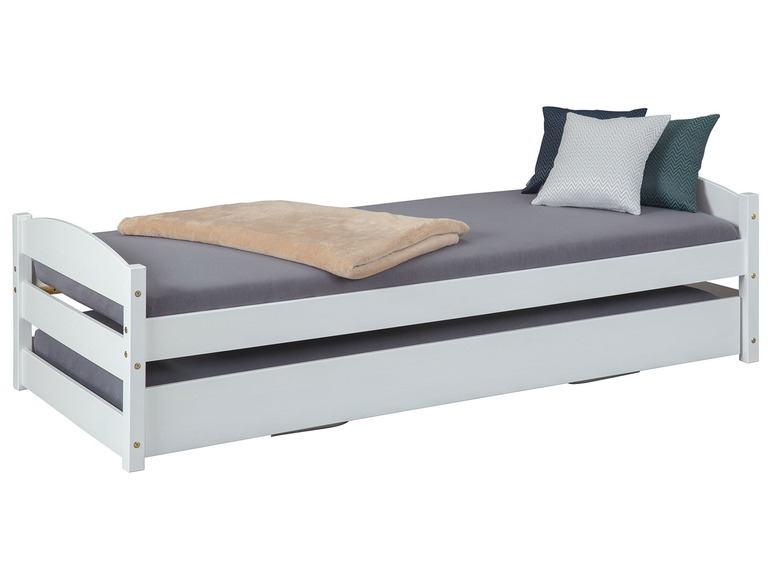 Wit houten bed met uittrekbaar bed en kussens.