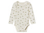 Een wit babypak met lange mouwen met een bijenprint.