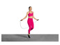 Een vrouw in roze sportkleding springt over een springtouw.