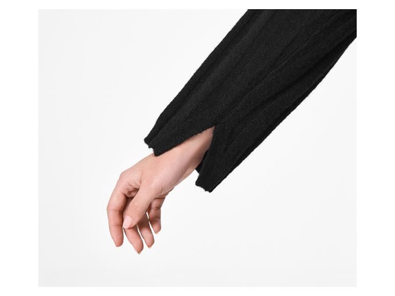 Hand van een persoon in een zwarte truimouw met een opening bij de manchet.