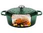Groene gietijzeren braadpan met een gebraden kip, knoflook en kruiden erin.