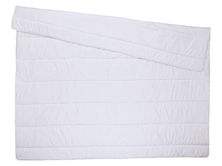 Wit dekbed met horizontale stiksels, gedeeltelijk gevouwen
