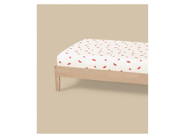 Wit hoeslaken met watermeloenpatroon op een houten bed.