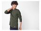 Mannelijk model in een olijfgroen henley shirt met lange mouwen.