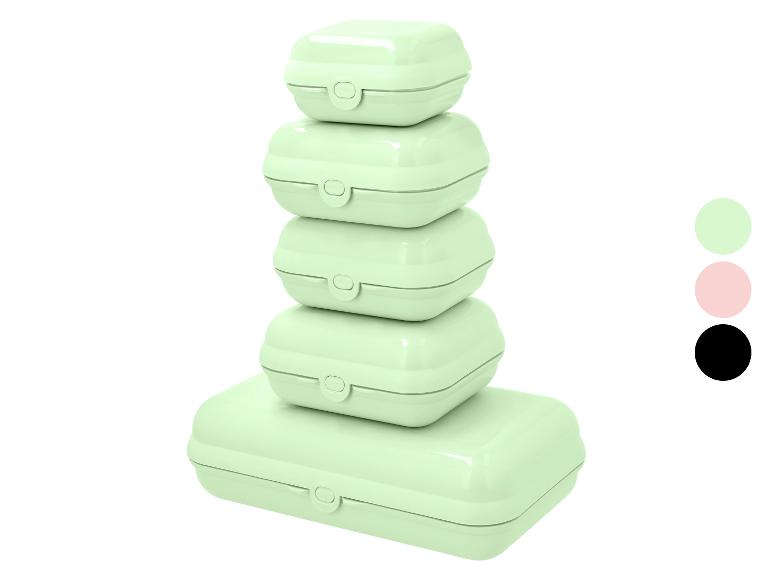 Stapel van vijf lichtgroene lunchboxen met sluitingen, met kleurstalen in groen, roze en zwart.
