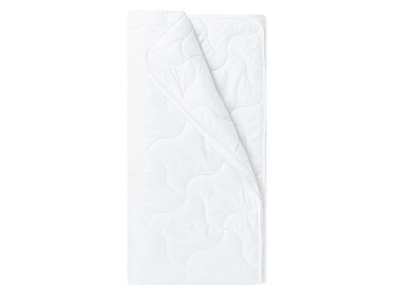 Wit, zacht en gewatteerd dekbed, opgevouwen.