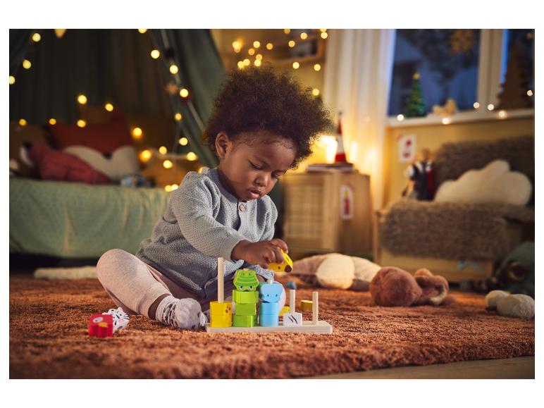 Een kind speelt met houten speelgoed in de vorm van dieren.