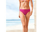 Een vrouw in roze bikini op het strand.