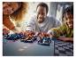 Een familie speelt met drie LEGO Speed Champions raceauto's op een baan.