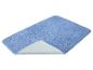 Blauwe badmat met een opgetilde hoek die de antislip achterkant toont