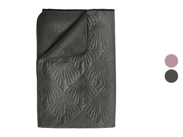 Donkergrijze deken met waaiervormig gewatteerd patroon en twee kleurmonsters.