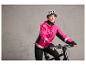 Vrouw op fiets met roze jas en helm.
