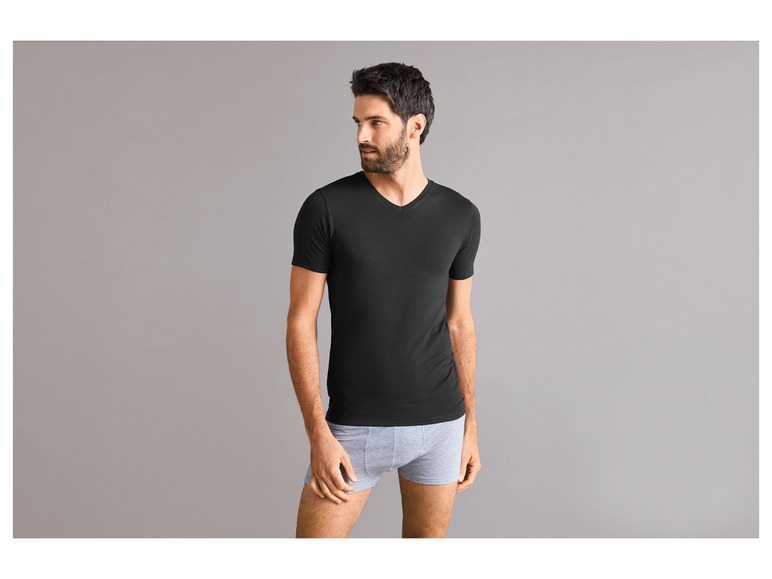 Man draagt een zwart T-shirt en grijze onderbroek.