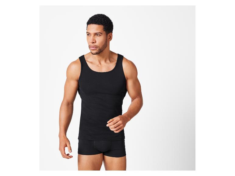Man draagt een zwart tanktop en zwarte boxershorts.