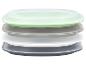 Stapel rechthoekige plastic voedselcontainers met deksels in groen, grijs en wit.